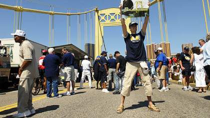 Steve Mellon/Post-Gazette
Marcin Witkowski, a student from Poznan, Poland, now studying at Indiana University of Pennsylvania, holds a sign celebrating the renaming of the 10th Street Bridge as the Philip Murray Bridge yesterday. Mr. Witkowski is pursuing a doctorate in labor history and labor relations.