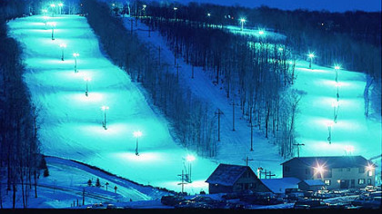 Two brightly lit intermediate slopes, Imperial, left, and Cobra, right, await evening skiers and snowboarders at Hidden Valley Four Seasons Resort. Between them is Road Runner, a narrow advanced trail that runs under the Lightning and Blizzard chairlifts.