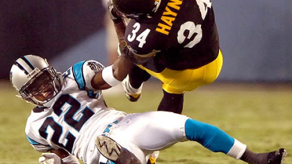 Verron Haynes is upended by the Panthers' Derrick Strait in the first half Thursday night. Haynes is fighting for one of the running back spots on the roster.