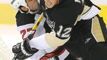 
The Penguins' Ryan Malone collides with the Devils' Mike Mottau.