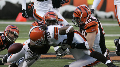 Cleveland Browns kick-returner Joshua Cribbs (16) fumbles the ball as he is tackled by Cincinnati Bengals defenders Chinedum Ndukwe (41) and Jim Maxwell (50) in the second half of yesterday's game in Cincinnati. Kyle Larson (19) watches. Cleveland recovered the fumble, but lost the game, 19-14.