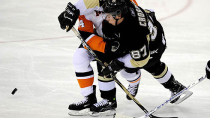 Penguins Sidney Crosby collides with the Islanders' Chris Campoli as he sets up a goal for teammate Jordan Staal in the second period.