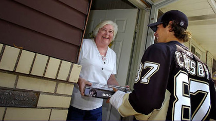 Pittsburgh Penguins team captaiin Sidney Crosby hand delivers tickets to season ticket holder Alice Kilgore.
