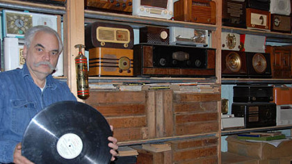 J. David Goldin holds one of his 16-inch glass disc recordings that were made in Pittsburgh during the 1940s. His home archives include thousands of various recordings.