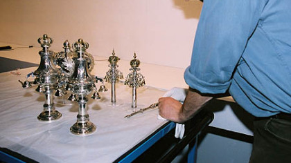 A conservator at Munich's Jewish Museum prepares Torah finials and a pointer for display a few days prior to the museum's opening on March 22, 2007.
