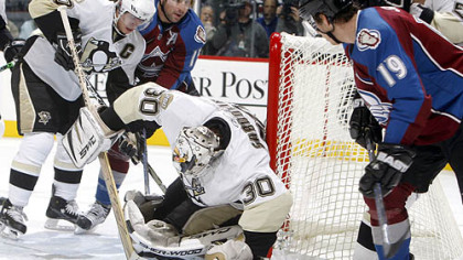 Penguins goalie Dany Sabourin, center, stops a shot off the stick of Colorado Avalanche's Joe Sakic, far right, as Penguins center Sidney Crosby, far left, comes in to cover with Avalanche left winger Andrew Brunette, second from left, in the first period of last night's hockey game in Denver.