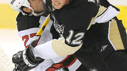 Ryan Malone collides with New Jersey's Mike Mottau last night at Mellon Arena in the longtime rivals' first meeting of the young season.