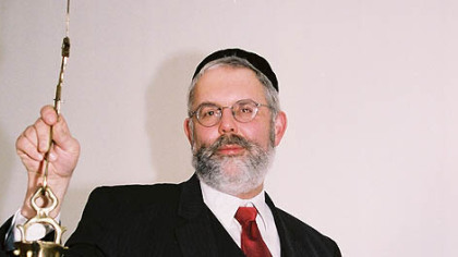 Rabbi Steven Langnas, who heads congregation Ohel Jakob, holds an antique Sabbath lamp such as all German-Jewish families would have used in the 19th century.