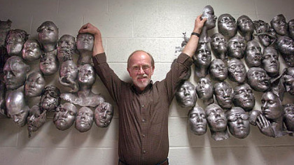 
     Carnegie Mellon University art professor Ron Bennett stands between some of the aluminum masks he and his sophomore art students have cast over the past 15 years in the basement of The University Center at Carnegie Mellon University.