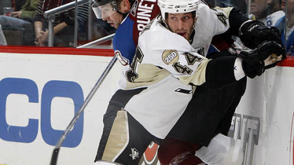 Penguins defenseman Brooks Orpik, front, pins Colorado Avalanche left winger Andrew Brunette to the boards while fighting for control of the puck in the first period last night's game in Denver.