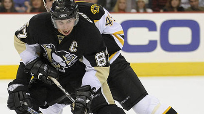 Sidney Crosby fights off the Bruins Mark Stuart at the Mellon Arena. (12/23/2007)