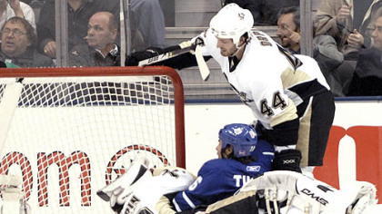 Penguins goalie Dany Sabourin, bottom, holds his head after a collision with the Maple Leafs' Darcy Tucker, center, as Brooks Orpik looks on in the first period Saturday in Toronto. Sabourin said he was not diagnosed with a concussion after the hit.