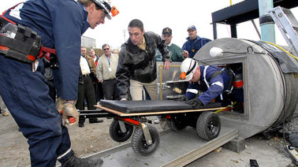 Engineers emerge from a demonstration of "The Great Escape," a mine escape system, at the Mine Safety and Health Administration's Approval & Certification Center near Triadelphia, W.Va. yesterday.  Trapped miners can ride the wheeled carts inside the tube to safety. (11/8/07)