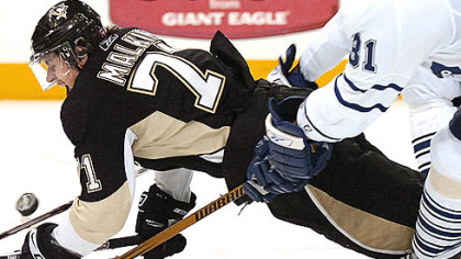 Penguins Evgeni Malkin is pulled down by the Leafs Pavel Kubina.