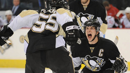 Sidney Crosby jumps into the arms of Sergei Gonchar after Gonchar scored the winning goal in overtime last night against Washington Capitals.