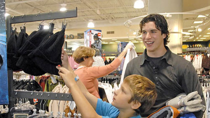 With shopping partner Penguins' forward Sidney Crosby in tow with his winter clothing selections, Austin Paterson, 10, shops for a winter hat during a Project Bundle-up shopping outing at Dick''s Sporting Goods in the Mall at Robinson yesterday.