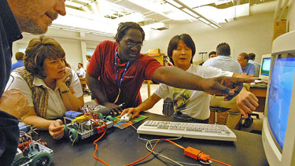 From left, Steve Schultz, of Wodstock Vt.; Julie Sweeney, of Sioux City, Iowa; Ken Benjamin, of Pittsburgh, and Clarence Chu, of Dayton, Ohio, work on programming a robot vehicle to navigate a preset course during last week's robotics conference.