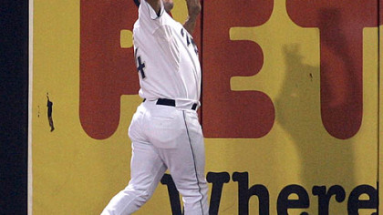 Padres outfielder Brian Giles feels for the wall as he makes the running catch on a ball hit by Jason Bay last night in San Diego.