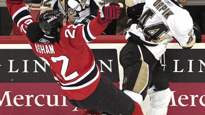The Devils' Arron Asham, left, loses his balance after colliding with Brooks Orpik in the second period last night in Newark, N.J.