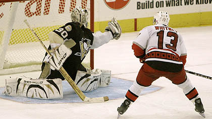 Penguins goalie Dany Sabourin, left, makes a save on Carolina Hurricanes' Ray Whitney in the shootout, giving the Penguins a 4-3 win at the Mellon Arena last night.