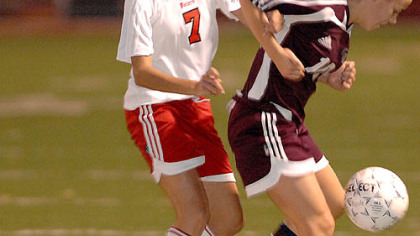 Peters Township's Mackenzie Creehan, left, battles Caroline Kimmich of Oakland Catholic for the ball last night in their WPIAL playoff game. Peters advances with a 4-0 win.