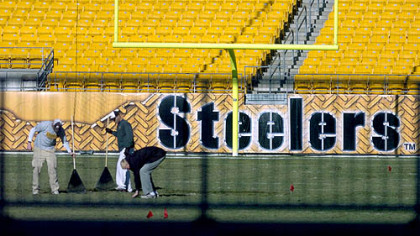 Staff members tend to Heinz Field yesterday to prepare it for Sunday's game with Cincinnati.