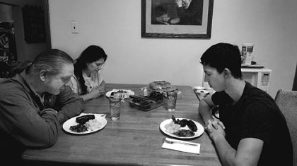Before a recent dinner, David Marks, left, says grace with his wife, Kathia, and son, Joseph. On the wall is a print of the famous painting "Grace" by Eric Enstrom (based on Mr. Enstrom's 1918 photo). Mr. Marks, who inherited it from an uncle years ago, says, "The print is beautiful and is a profound example of humility, thankfulness and peace."