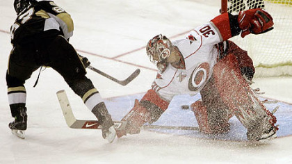 Sidney Crosby, left, scores on Carolina Hurricanes goalie Cam Ward in last night's shoot out.