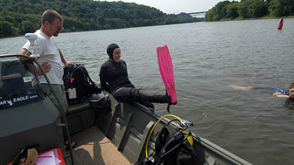 Eric Chapman, director of aquatic science, looks on diver Tamara Smith prepares to jump in, joining diver Jake Winkler already in the river.