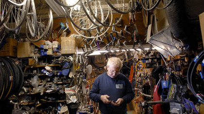 Jerry Kraynick sorts through some items as he creates space in his crowded Garfield bike shop last week for bicycles that will be donated to needy kids. Mr. Kraynick is co-director of The Bike Before Christmas program.