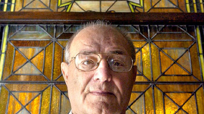 Dr. Allan Drash stands in front of a stained glass window in his apartment building that says "nature fits all her children with something to do," a quote he likes and finds fitting after spending 40 years at Children's Hospital as a world-renowned pioneer in diabetes care and research.