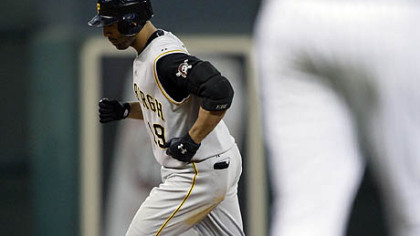 The Pirates' Jose Bautista, background, runs the bases after hitting a two-run home run off Houston Astros pitcher Chad Qualls, foreground, during the eighth inning of last night's game in Houston.