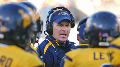 West Virginia coach Rich Rodriguez, center, talks with his players.