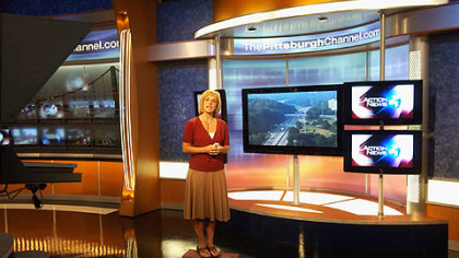 Melanie Taylor, traffic reporter, rehearses in the reporter stand-up part of Channel 4's new set, an area that looks a little bit like the transporter pad from "Star Trek."