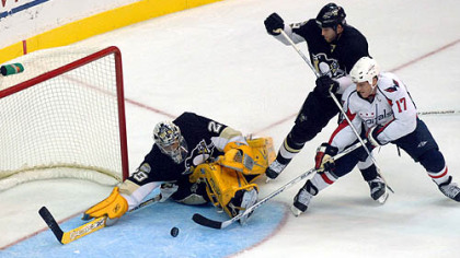 Penguins goalie Marc-Andre Fleury, left, makes a save on a shot by Washington Capitals' Chris Clark (17) as Penguins' Ryan Whitney looks on during the third period last night.