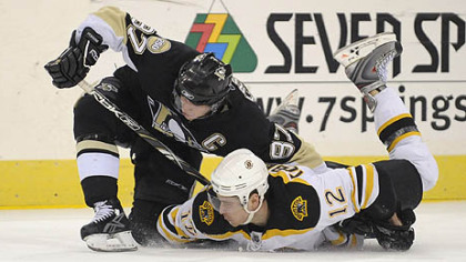 Sidney Crosby battles for loose puck with the Bruins Chuck Kobasew in the third period at the Mellon Arena. 
(12/23/2007)