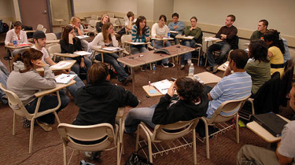 Duquesne students in a forensic sciences class gather around a speaker phone to talk with serial killer Keith Hunter Jesperson.